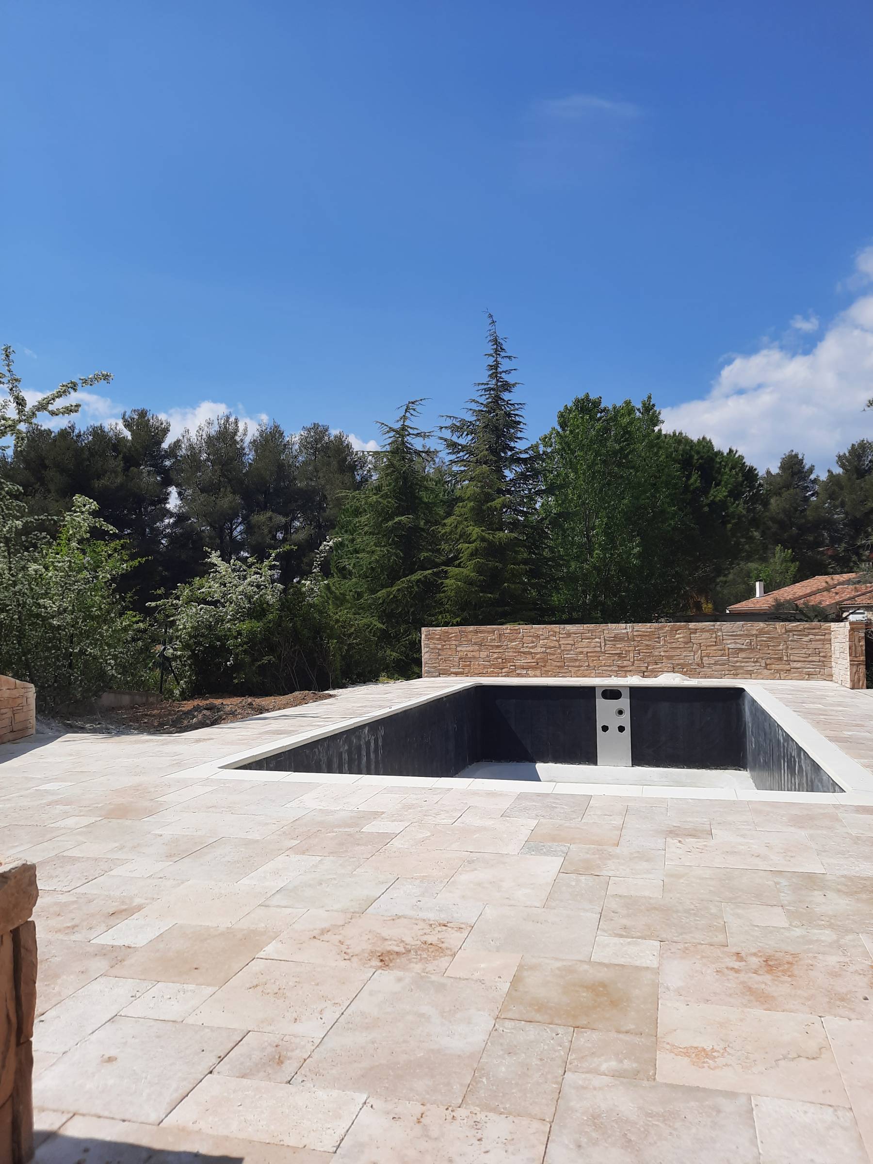 réalisation plage piscine en travertin et mur avec pierre de parements