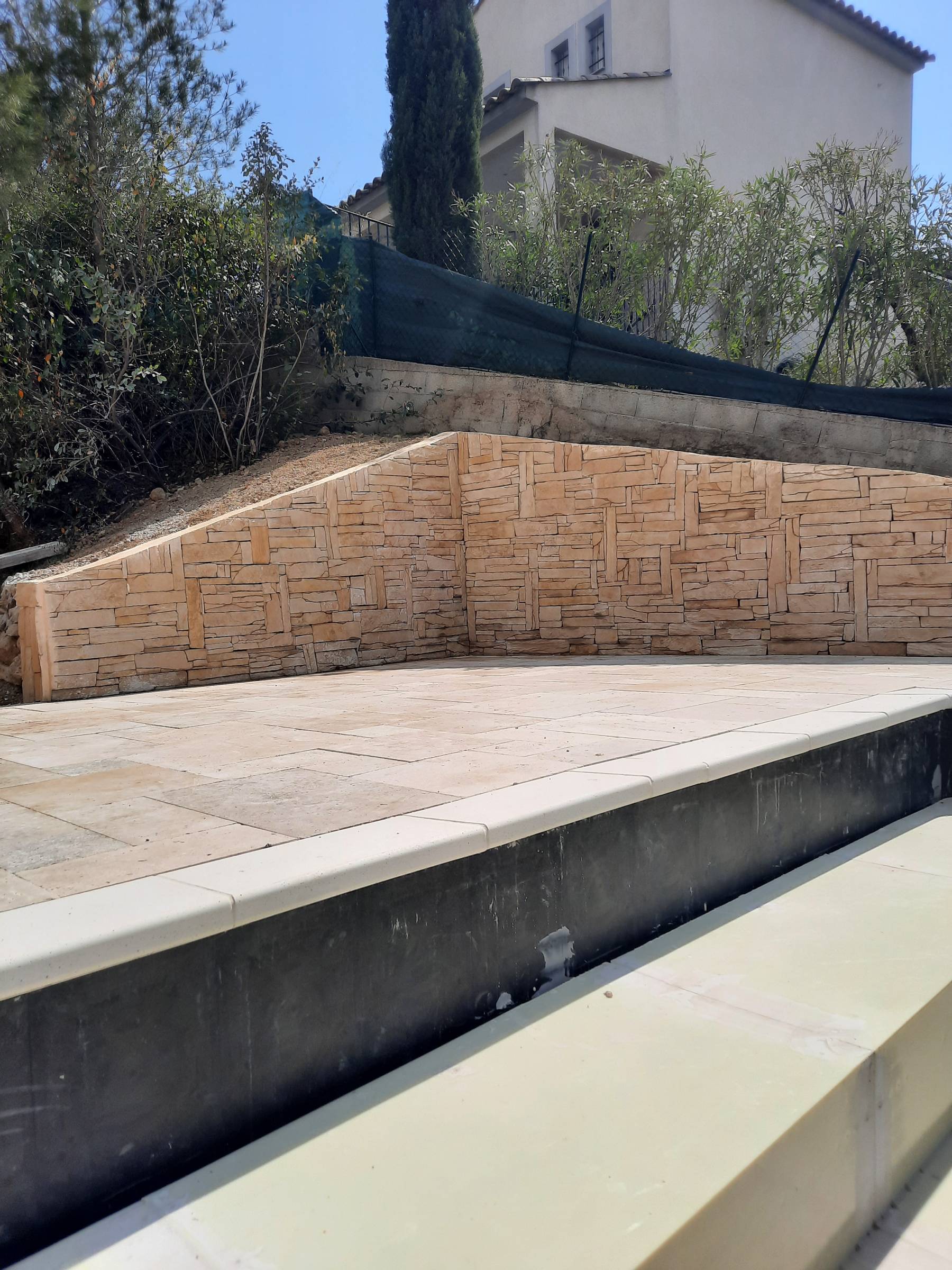 réalisation plage piscine en travertin et mur avec pierre de parements