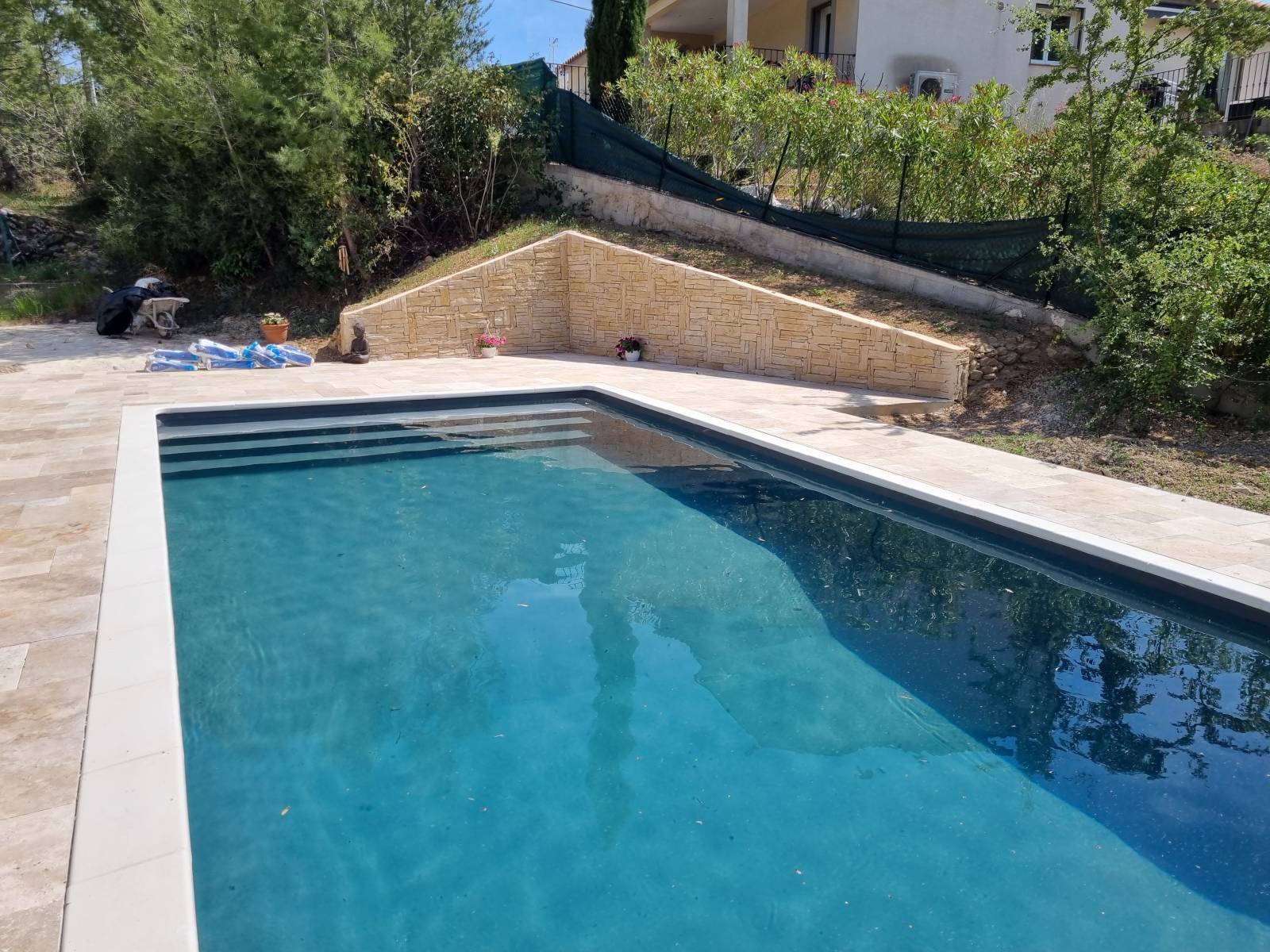 réalisation plage piscine en travertin et mur avec pierre de parements