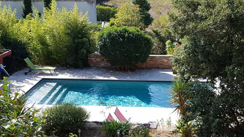 piscine 9 x 4 m grise avec du travertin 